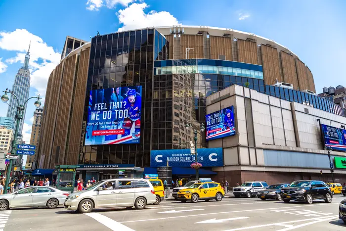 Madison Square Garden photographed from the outside with a yellow taxi in front.